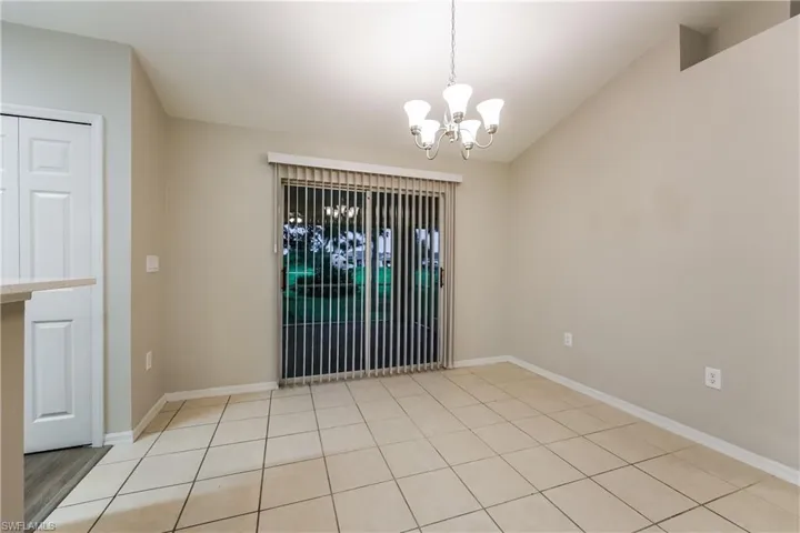 Empty room featuring a chandelier and light tile patterned flooring
