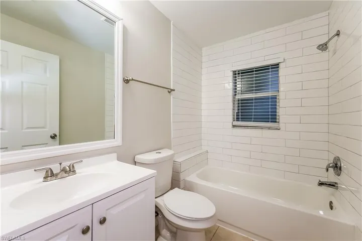 Bathroom featuring bathtub / shower combination, vanity, and tile patterned flooring