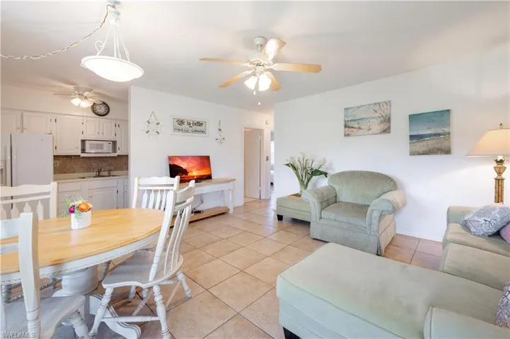 Living room with ceiling fan and light tile patterned flooring
