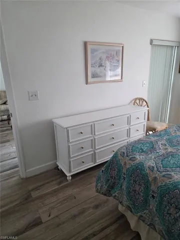 Bedroom featuring dark wood finished floors and baseboards