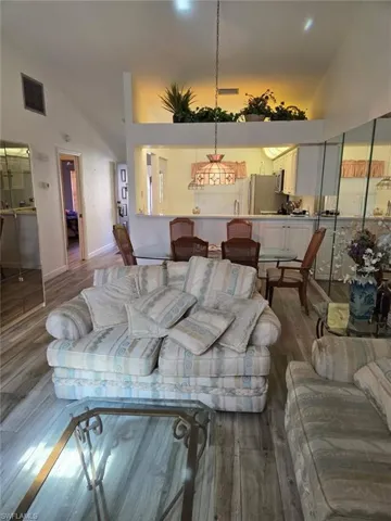 Living area featuring high vaulted ceiling and wood finished floors
