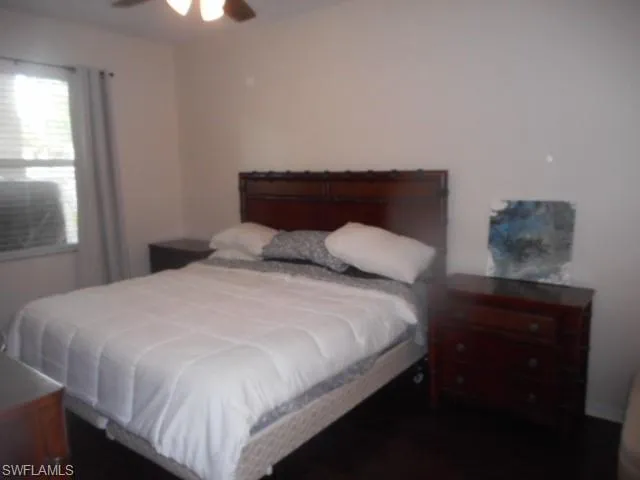 Bedroom with ceiling fan and dark wood-style floors