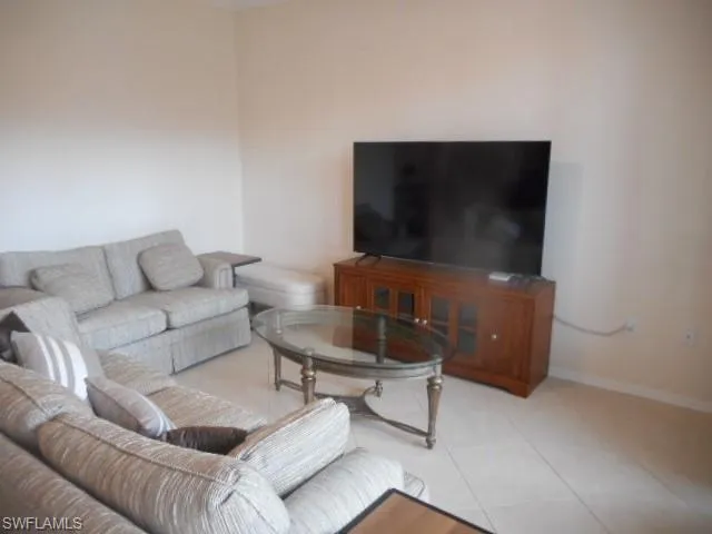 Tiled living room featuring baseboards