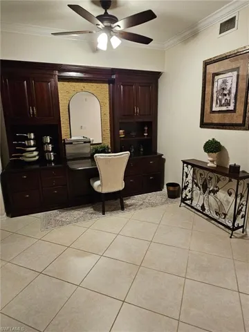 Full bathroom with crown molding, light tile patterned floors, vanity, and a ceiling fan