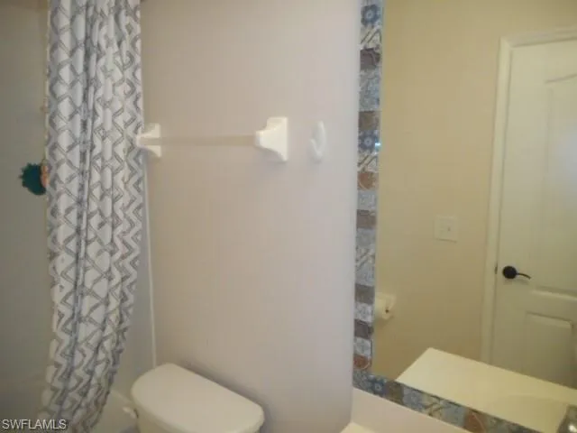 Bathroom with shower / tub combo with curtain and vanity