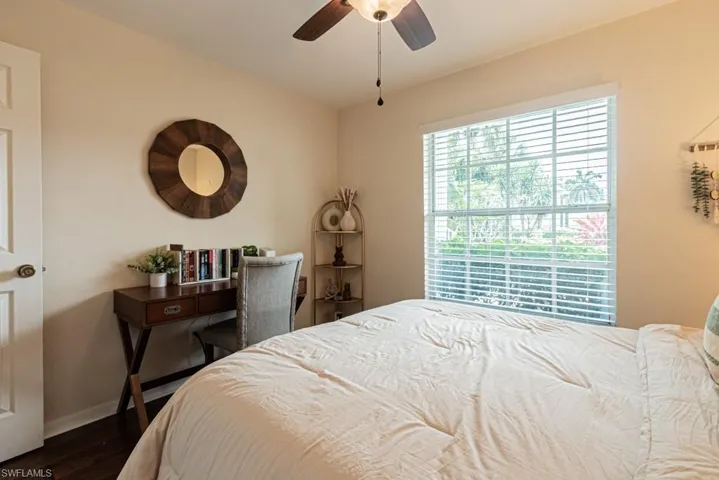 Bedroom featuring dark wood-type flooring, baseboards, and ceiling fan