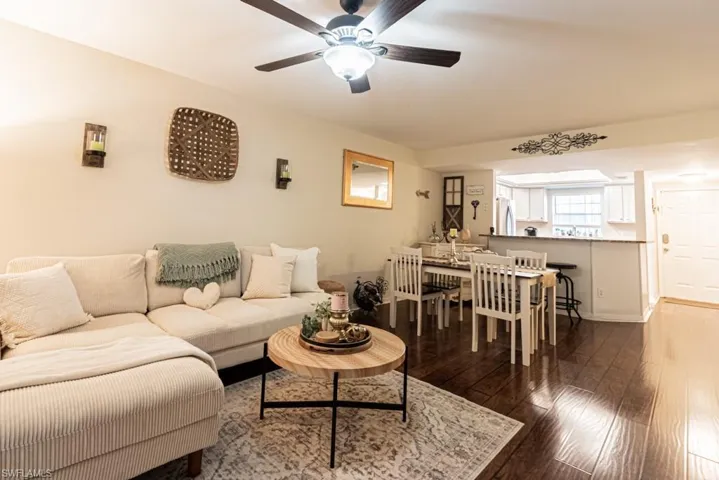 Living area with dark wood-type flooring and ceiling fan