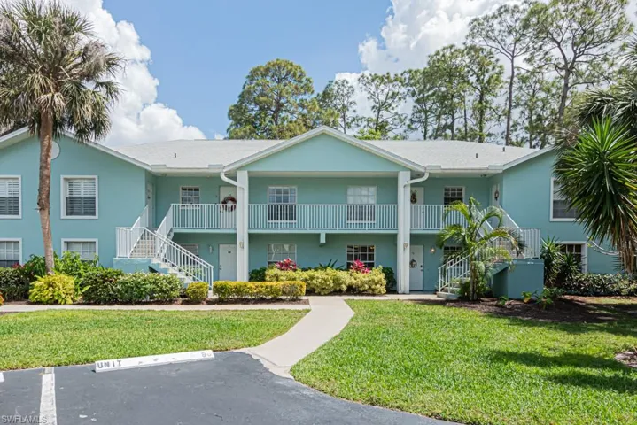 View of property featuring uncovered parking and stairway