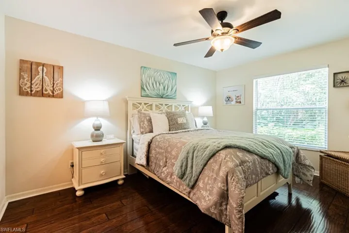 Bedroom with baseboards, a ceiling fan, and dark wood-style flooring