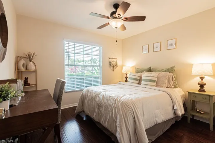 Bedroom with a ceiling fan, dark wood-type flooring, and baseboards