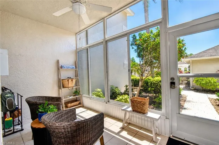 Screened lanai featuring large format tile flooring and a ceiling fan