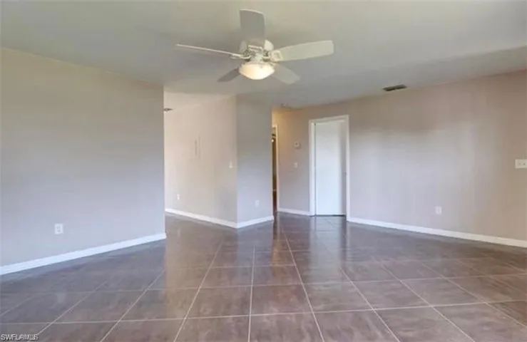Tiled empty room featuring ceiling fan