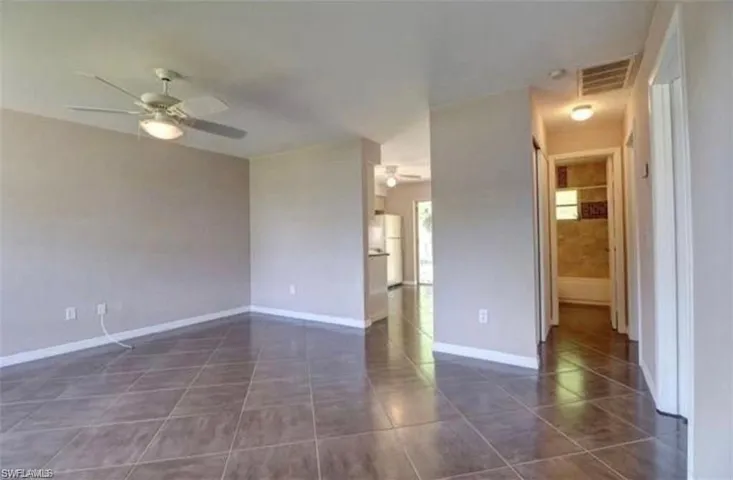 Spare room featuring ceiling fan and dark tile patterned floors