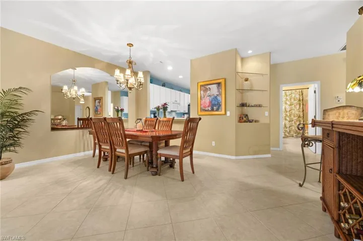 Dining area with light tile patterned flooring and a chandelier