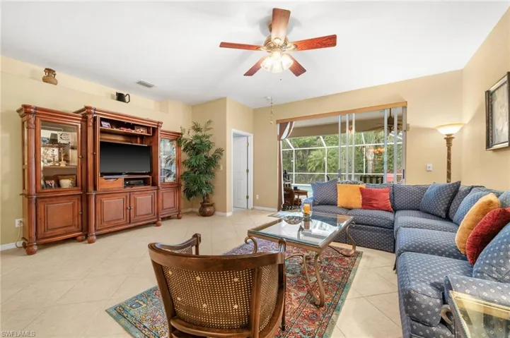 Living area with a sunroom, ceiling fan, and light tile patterned flooring