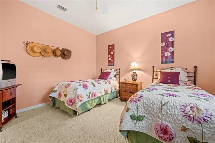 Carpeted bedroom with ceiling fan and baseboards