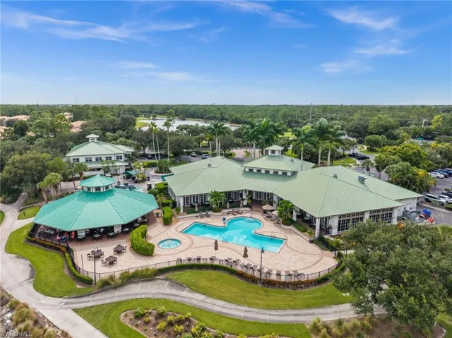 Drone / aerial view of a pool area and a tree filled landscape