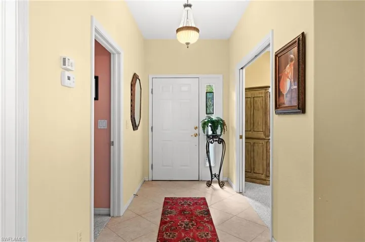 Foyer entrance with baseboards and light tile patterned floors