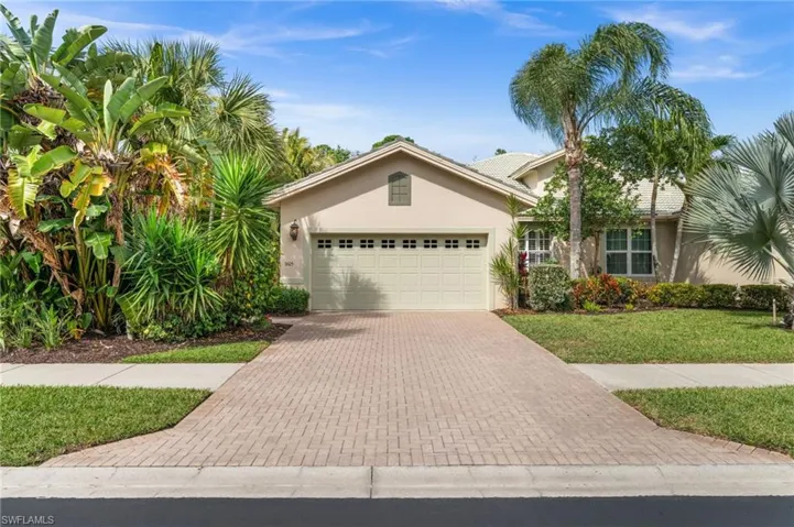 Ranch-style home with stucco siding, decorative driveway, an attached garage, and a front yard