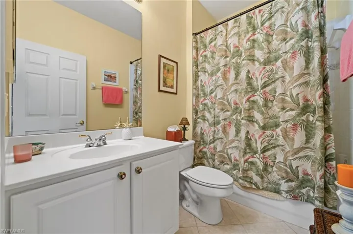 Bathroom with vanity, light tile patterned floors, and shower / bath combo