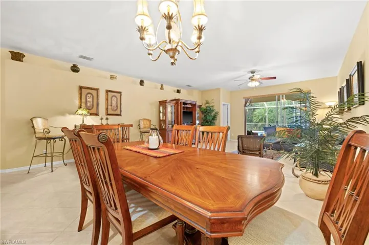 Tiled dining room featuring hanging lights and ceiling fan