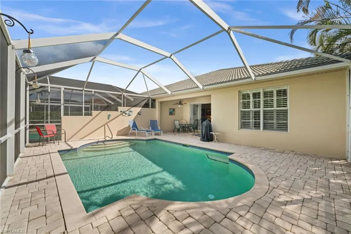 Swimming pool featuring a patio area, a sunroom, and glass enclosure