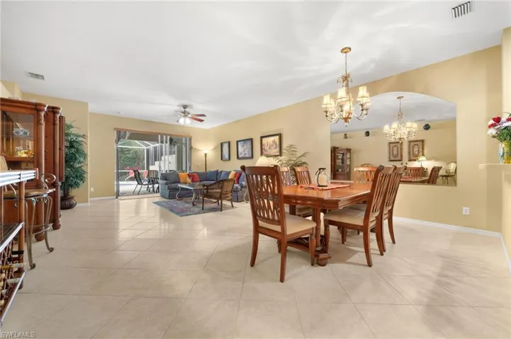 Dining space with a ceiling fan, suspended lighting, and light tile patterned floors