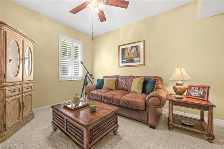 Living room featuring a ceiling fan and light colored carpet