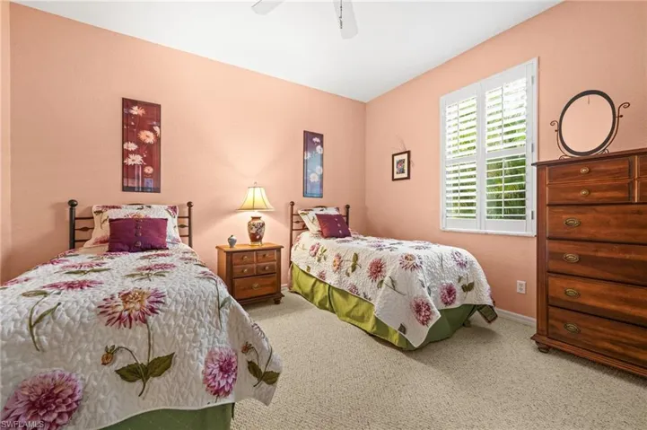 Carpeted bedroom with ceiling fan and baseboards