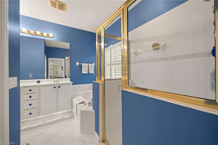 Full bath with a bath, a stall shower, vanity, and tile patterned floors