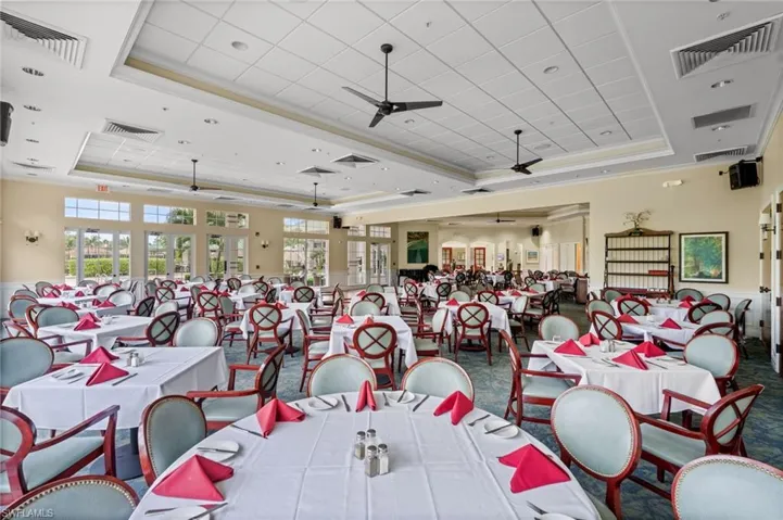 Carpeted dining space with a ceiling fan, ornamental molding, and a tray ceiling