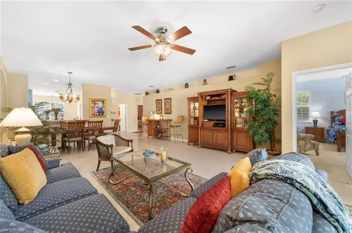 Living room featuring ceiling fan, suspended lighting, and light tile patterned floors