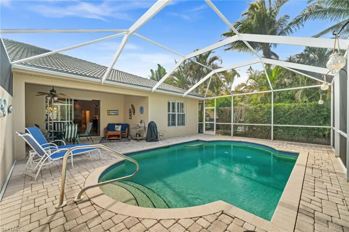 Outdoor pool with a patio area, a sunroom, and a lanai