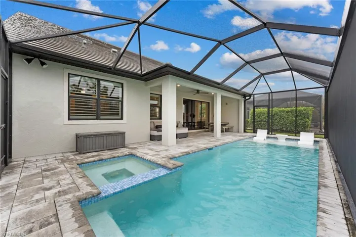 View of pool featuring an in ground hot tub, a lanai, an outdoor hangout area, ceiling fan, and a patio area
