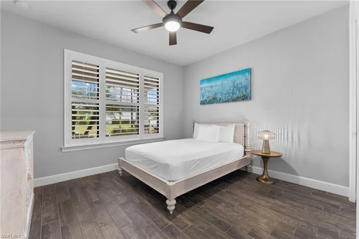 Bedroom featuring dark wood-type flooring and ceiling fan