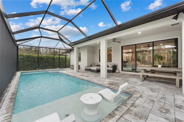 View of pool with a lanai, an outdoor hangout area, ceiling fan, and a patio area