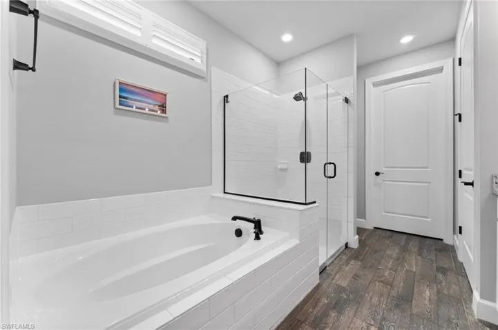 Bathroom featuring independent shower and bath and hardwood / wood-style floors