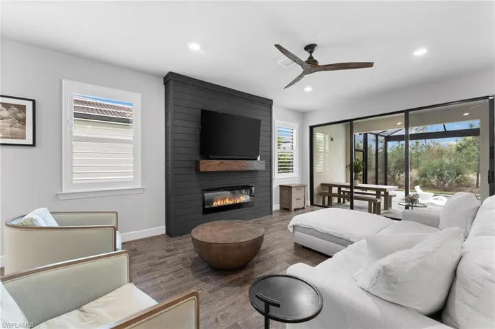 Living room with ceiling fan and a large fireplace