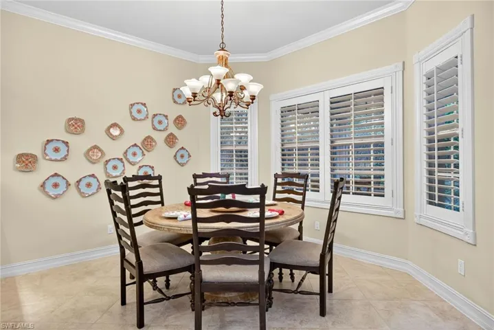 Dining space featuring ornamental molding, a chandelier, and light tile patterned floors
