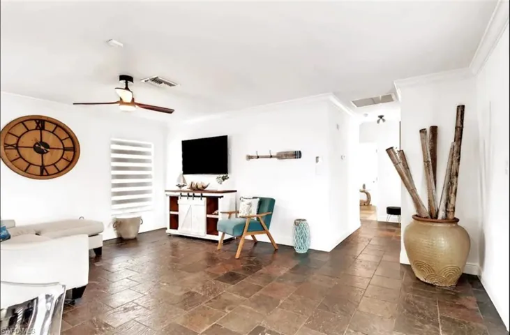 Living room with crown molding and ceiling fan