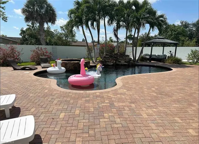 View of pool with a patio area and a gazebo