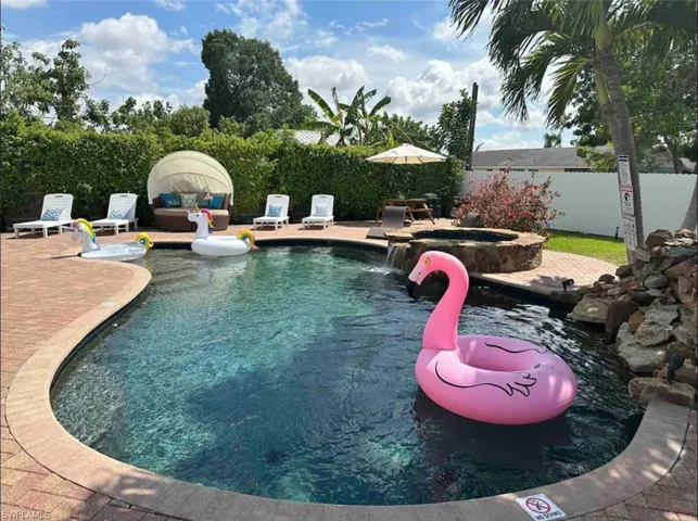 View of pool with an in ground hot tub, pool water feature, and a patio