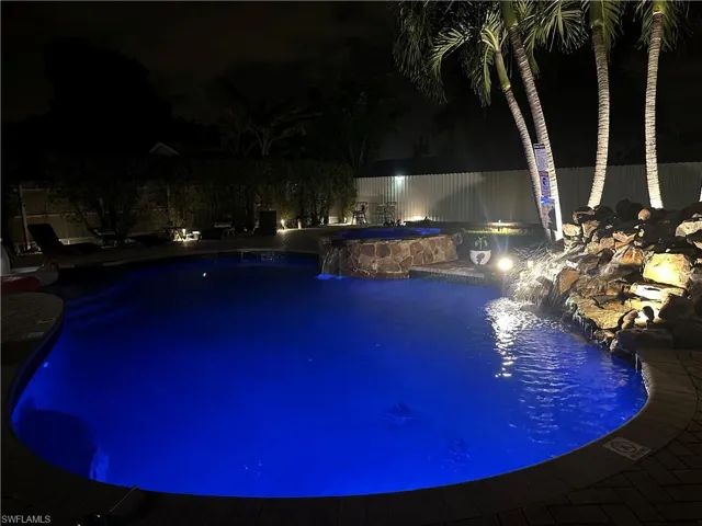 Pool at night with pool water feature