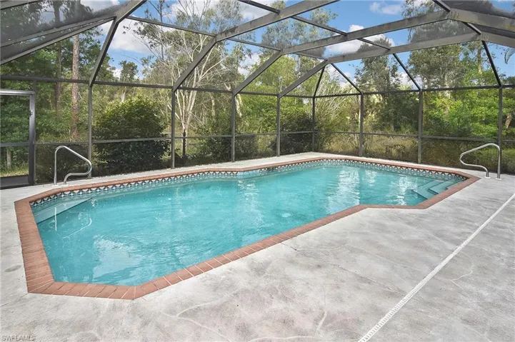 View of swimming pool with a patio and glass enclosure