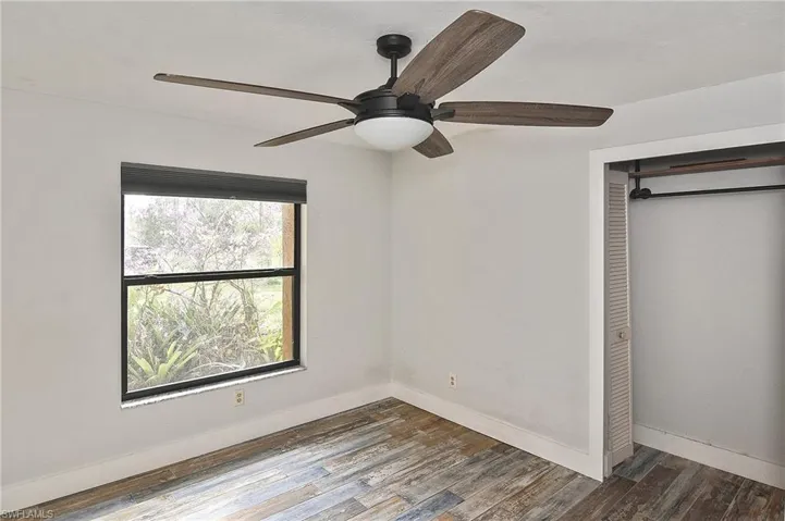 Unfurnished bedroom with hardwood / wood-style floors, a closet, and ceiling fan