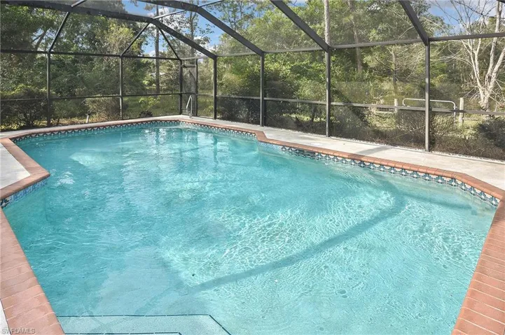 View of swimming pool featuring a lanai