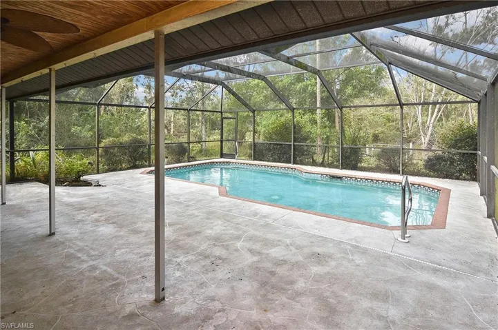 View of pool with a lanai, ceiling fan, and a patio area