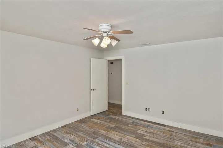 Unfurnished room featuring dark hardwood / wood-style floors and ceiling fan
