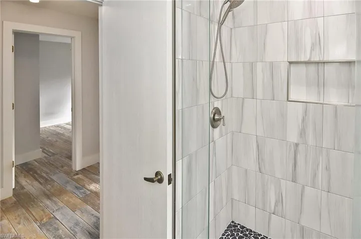 Bathroom featuring a tile shower and hardwood / wood-style flooring