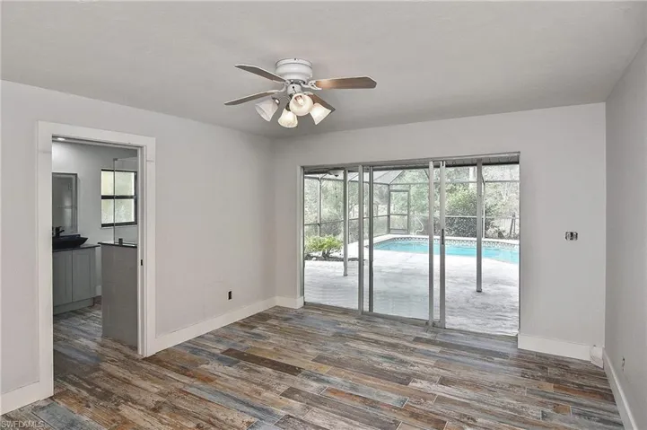Empty room featuring dark wood-type flooring and ceiling fan
